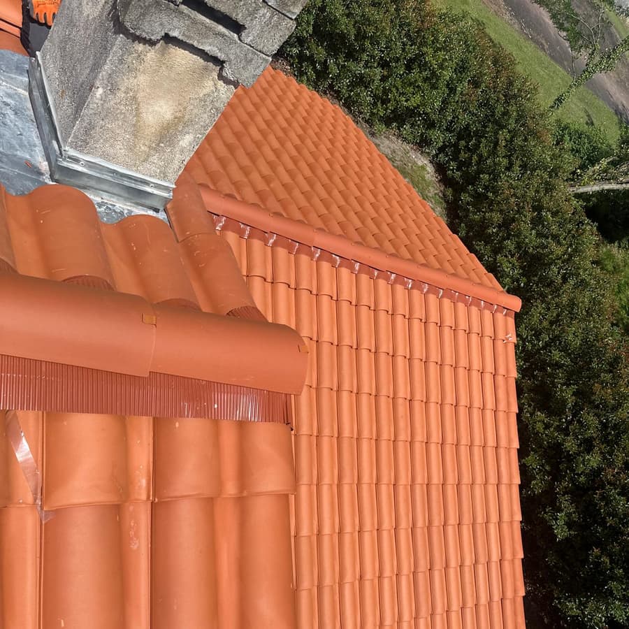 Arêtier et tuiles neuves posés avec soin lors d'une rénovation